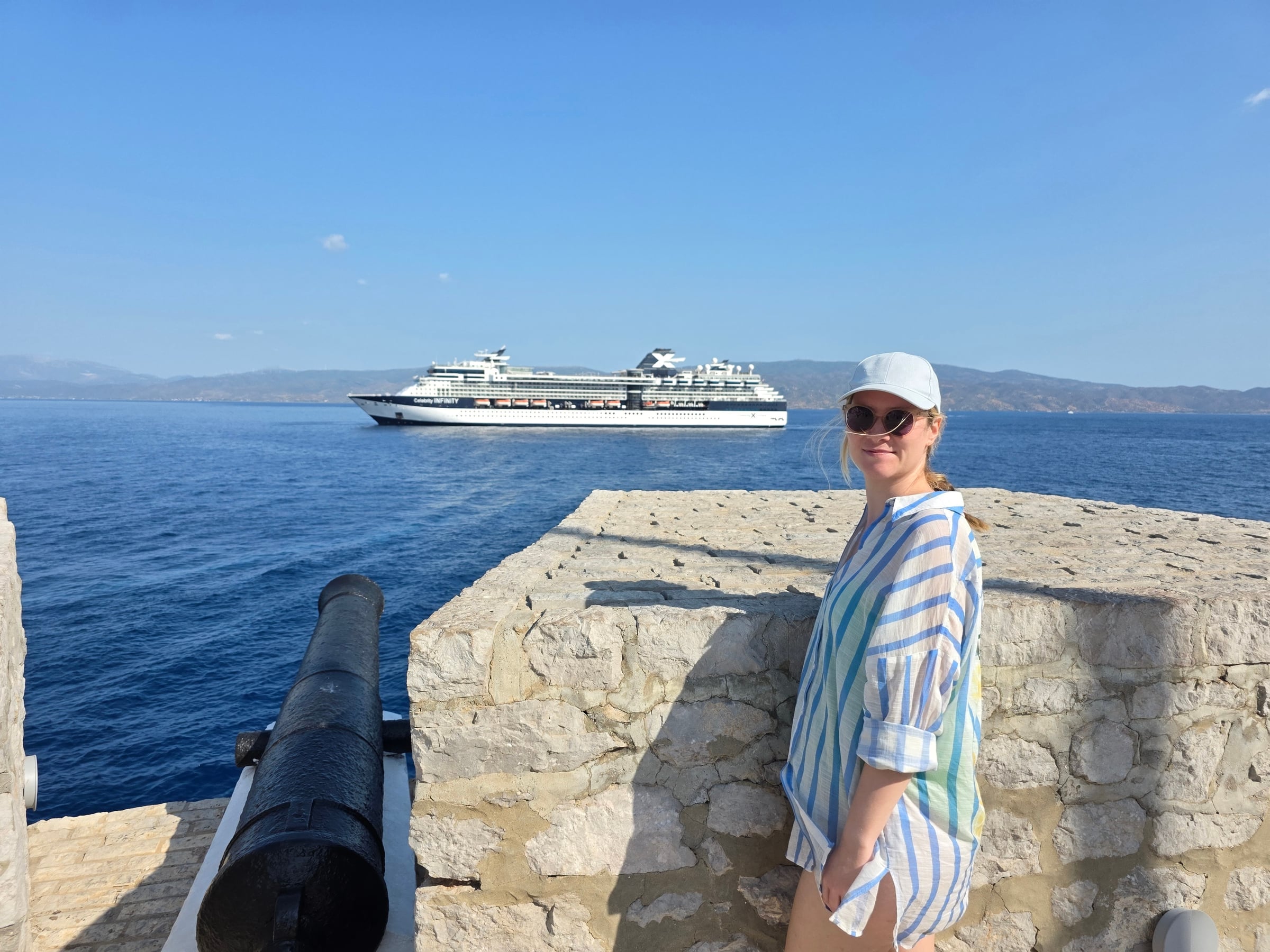 Lucy by the harbour cannon, with Infinity offshore.