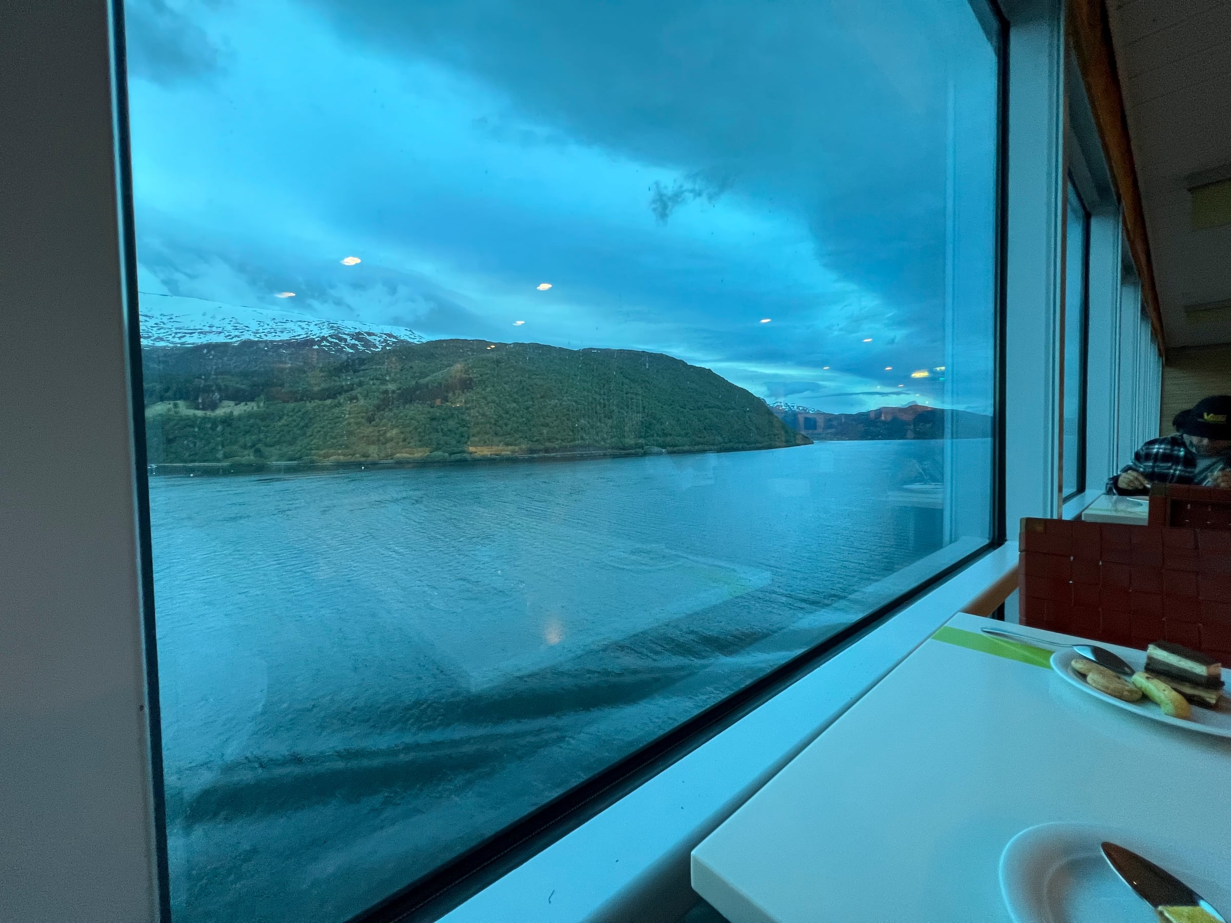 A table beside the windows, with the Norwegian coast outside.